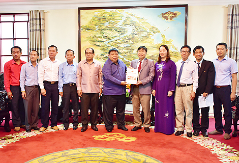 Đồng chí chí Pom Pet Khiu La Vong, Phó Bí thư Tỉnh ủy, Trưởng Đoàn đại biểu Quốc hội, Chủ tịch HĐND tỉnh Sê Kông tặng sách lịch sử tỉnh Sê Kông cho lãnh đạo tỉnh 